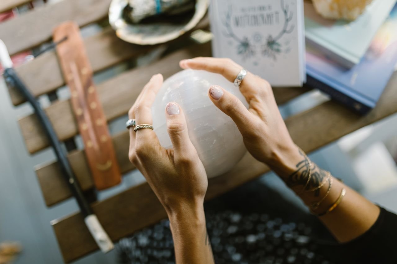 Mysterious image of hands holding a glowing crystal ball, hinting at magic and divination.