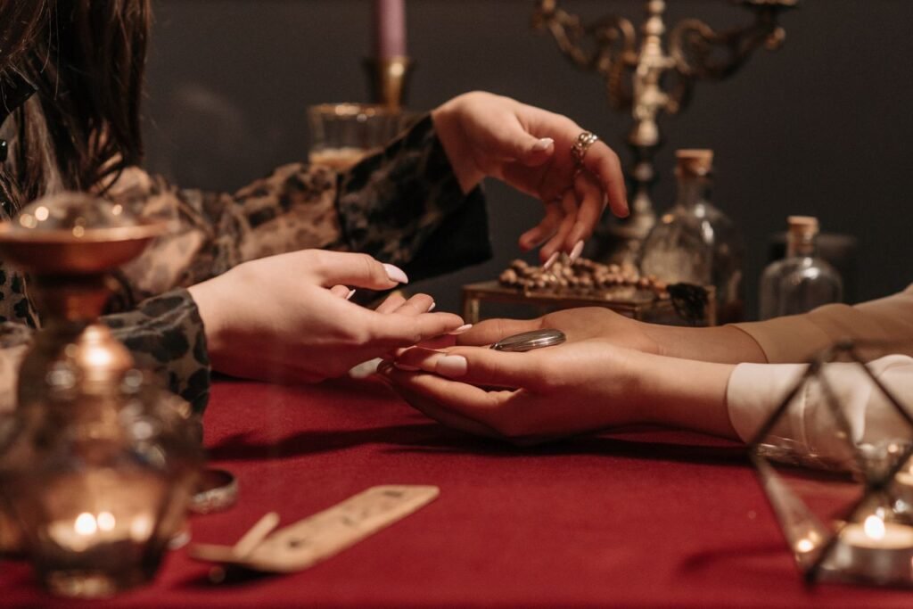 Rituale per Attirare la Ricchezza: Aprire le Porte dell'Abbondanza A fortune teller delicately reading a client's palm in a mystic setting with enchanting ambiance.